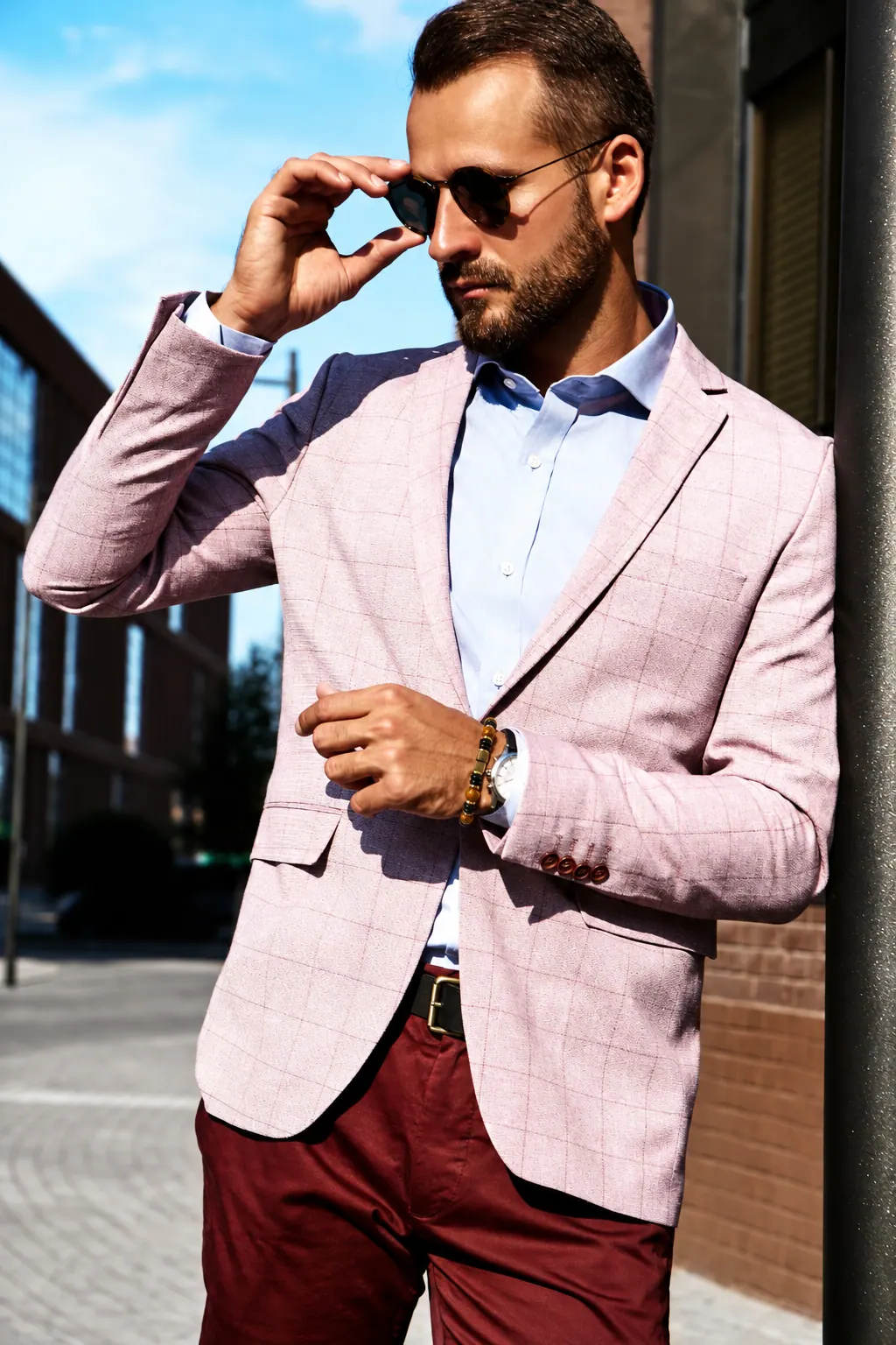 Homem de blazer rosa usando a pulseira Farol no pulso
